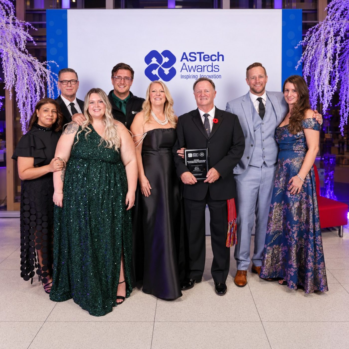 Clearflow team standing with Jerry Hanna holding an ASTech Awards plaque in front of the ASTech Awards Inspiring Innovation backdrop