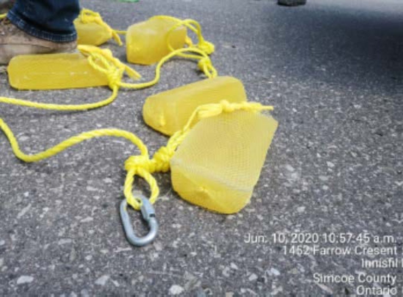 Yellow Gel Floc blocks strung together with polyethylene rope and carabiners on pavement