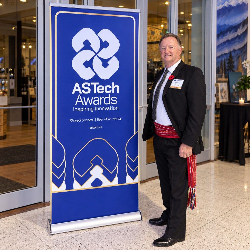 Jerry Hanna wearing a Métis sash beside the ASTech Awards Inspiring Innovation banner
