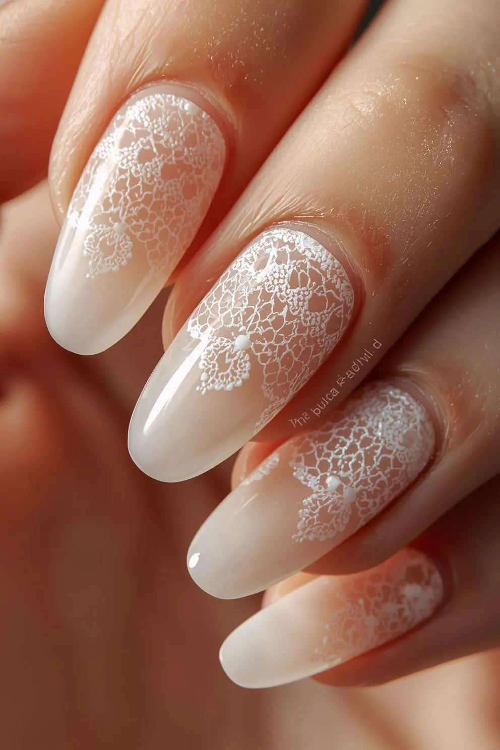 Milky white ombre nails with delicate lace floral detailing on almond shape, soft romantic summer nail design with glossy finish