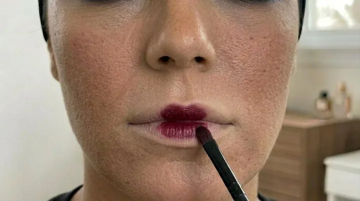 Deep wine lipstick applied to the center of the lips with a lip brush for a soft blurred lip effect.
