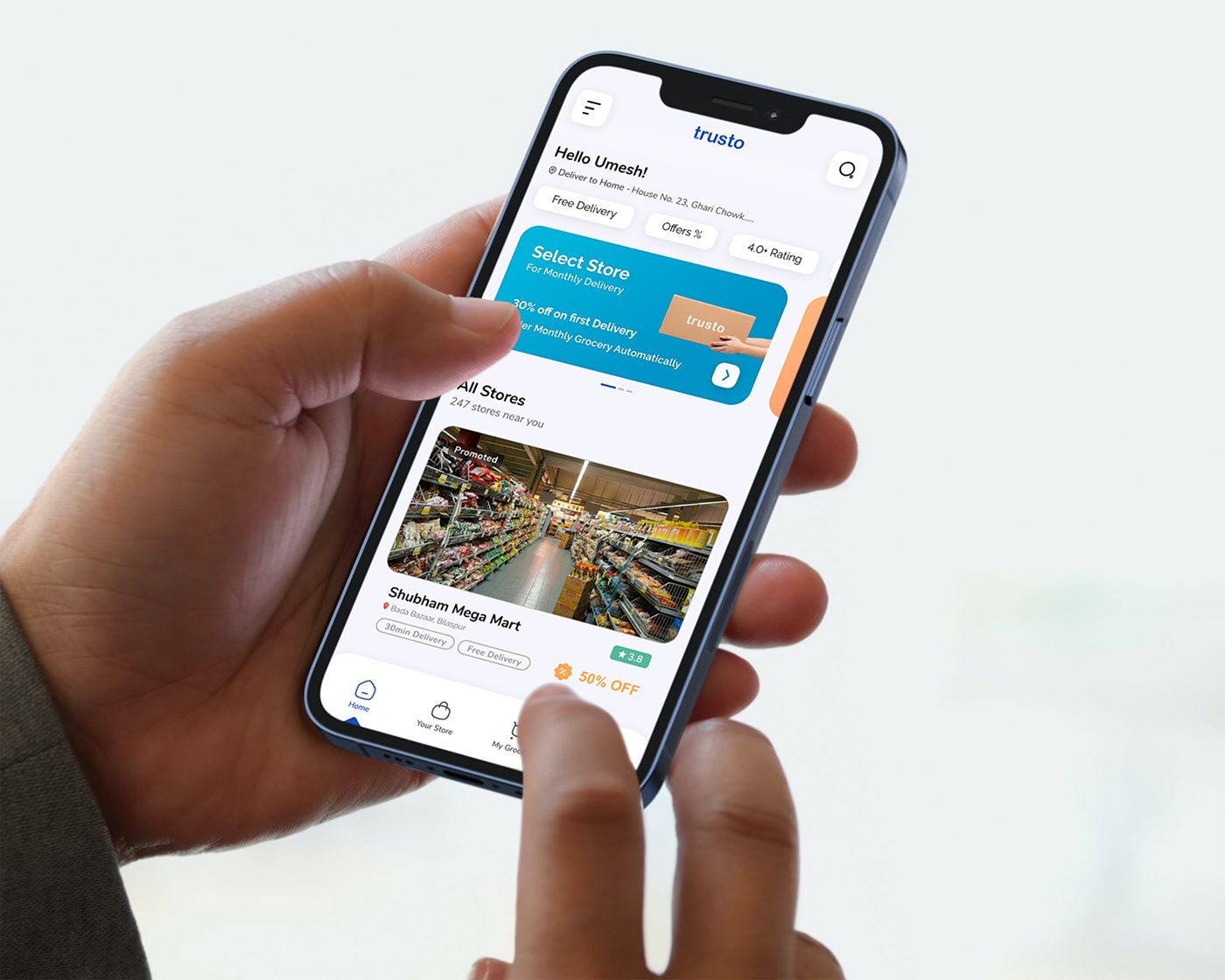 Hand holding a phone showing the Trusto app home screen