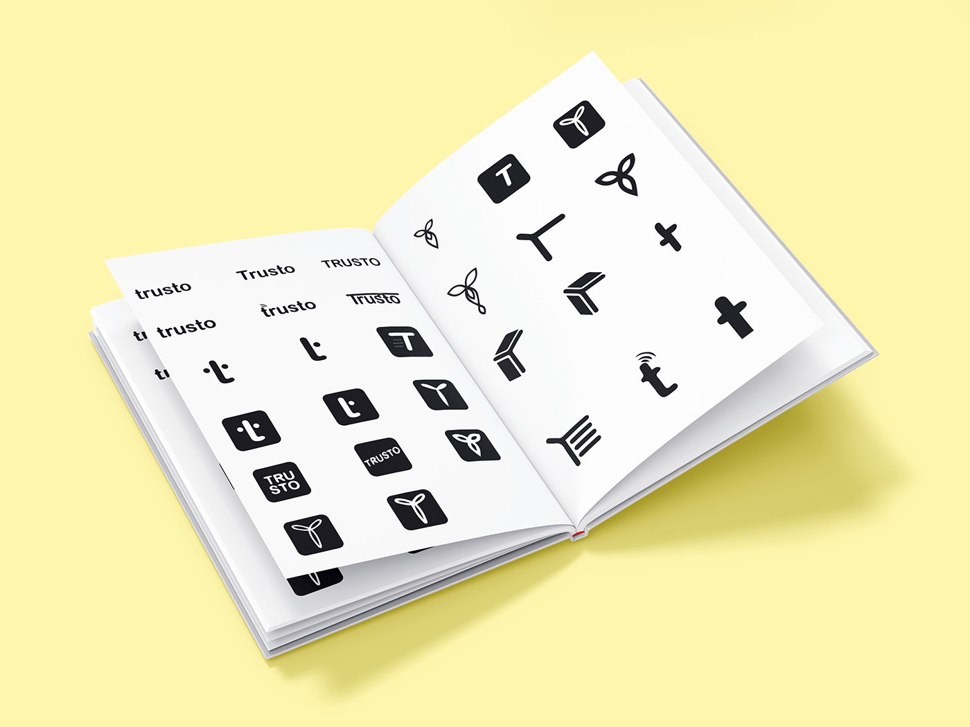 Open notebook with many black Trusto logo explorations built on the letter T