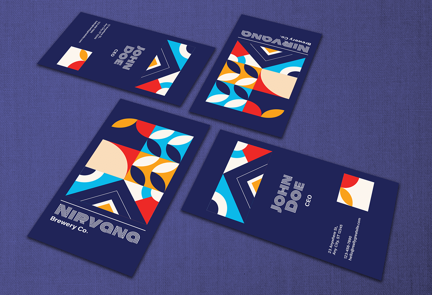 Nirvana business cards scattered on blue cloth, each with a different pattern crop