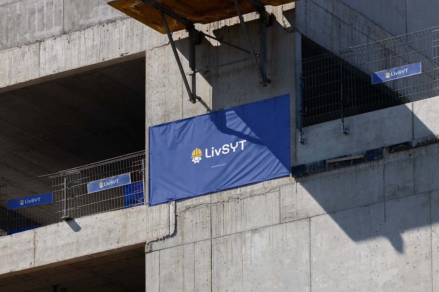 LivSYT blue banner hanging on a concrete construction site