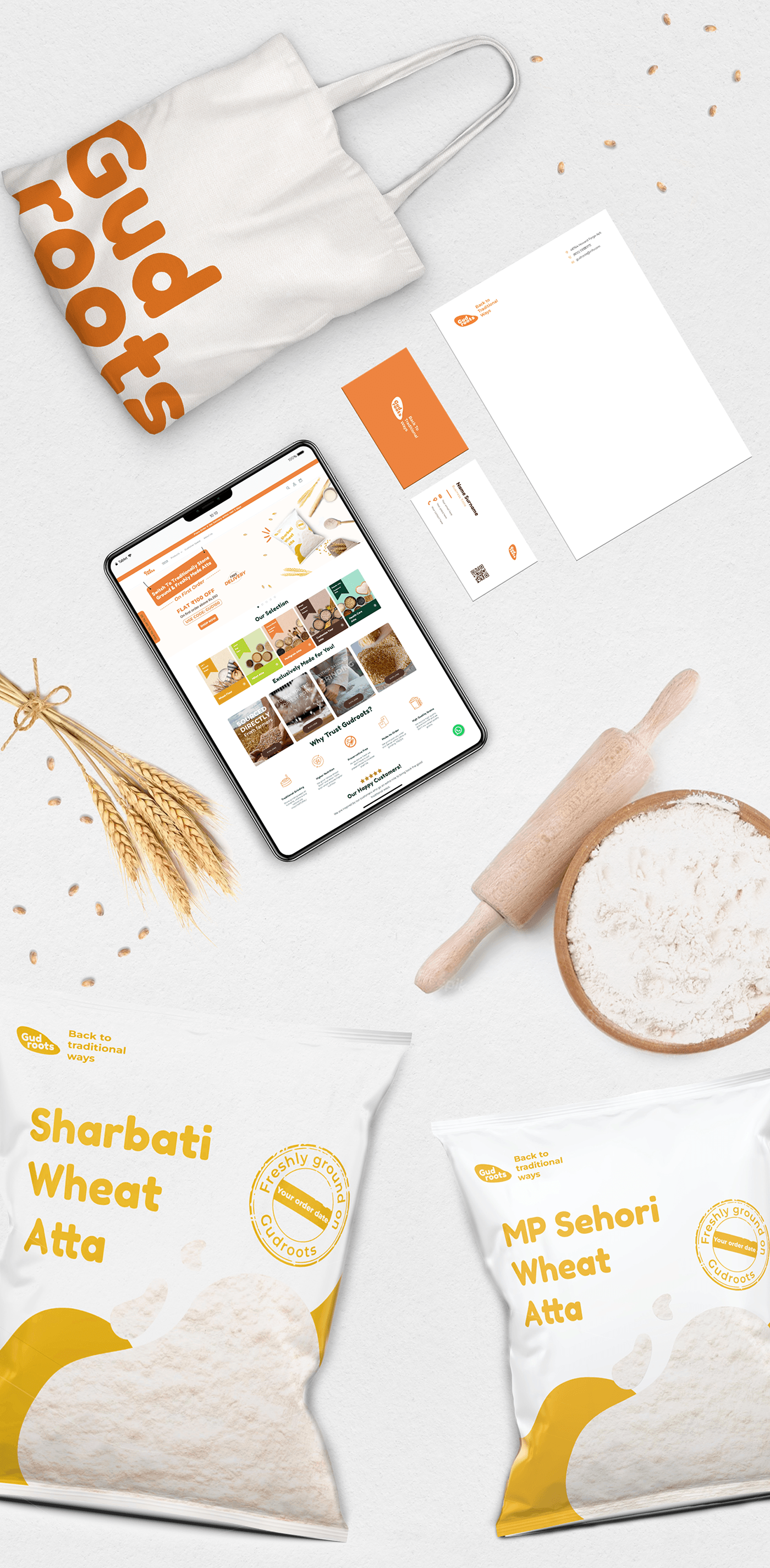 Gudroots flat lay with a tote bag, letterhead, tablet website and two atta pouches
