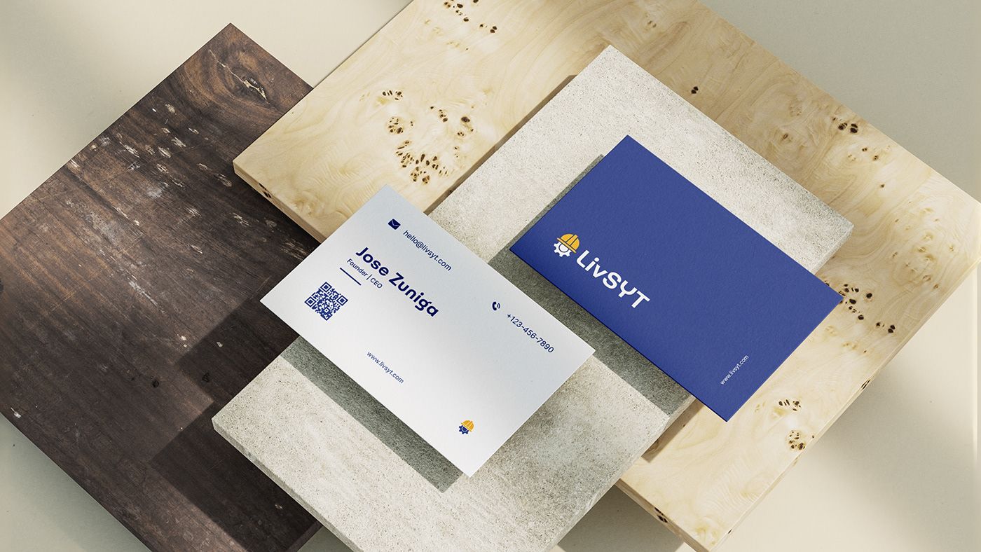 LivSYT navy and white business cards on wooden and stone surfaces