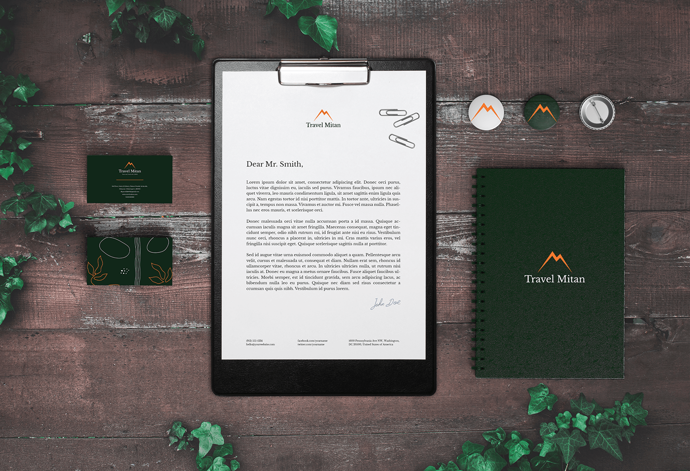 Travel Mitan stationery flat lay with a letterhead on a clipboard, a notebook, badges and business cards