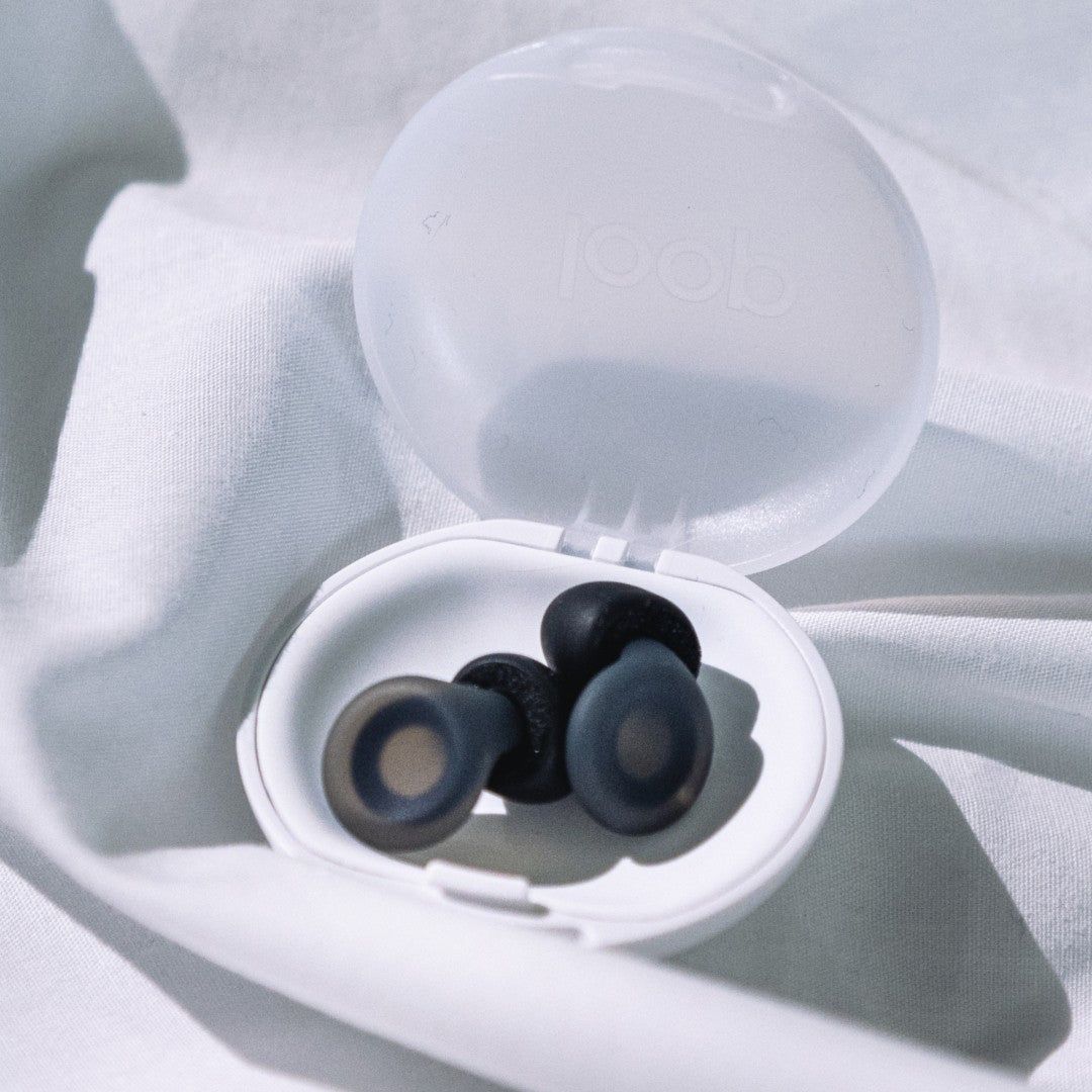 Black Loop Dream earplugs resting in their open bedside carry case