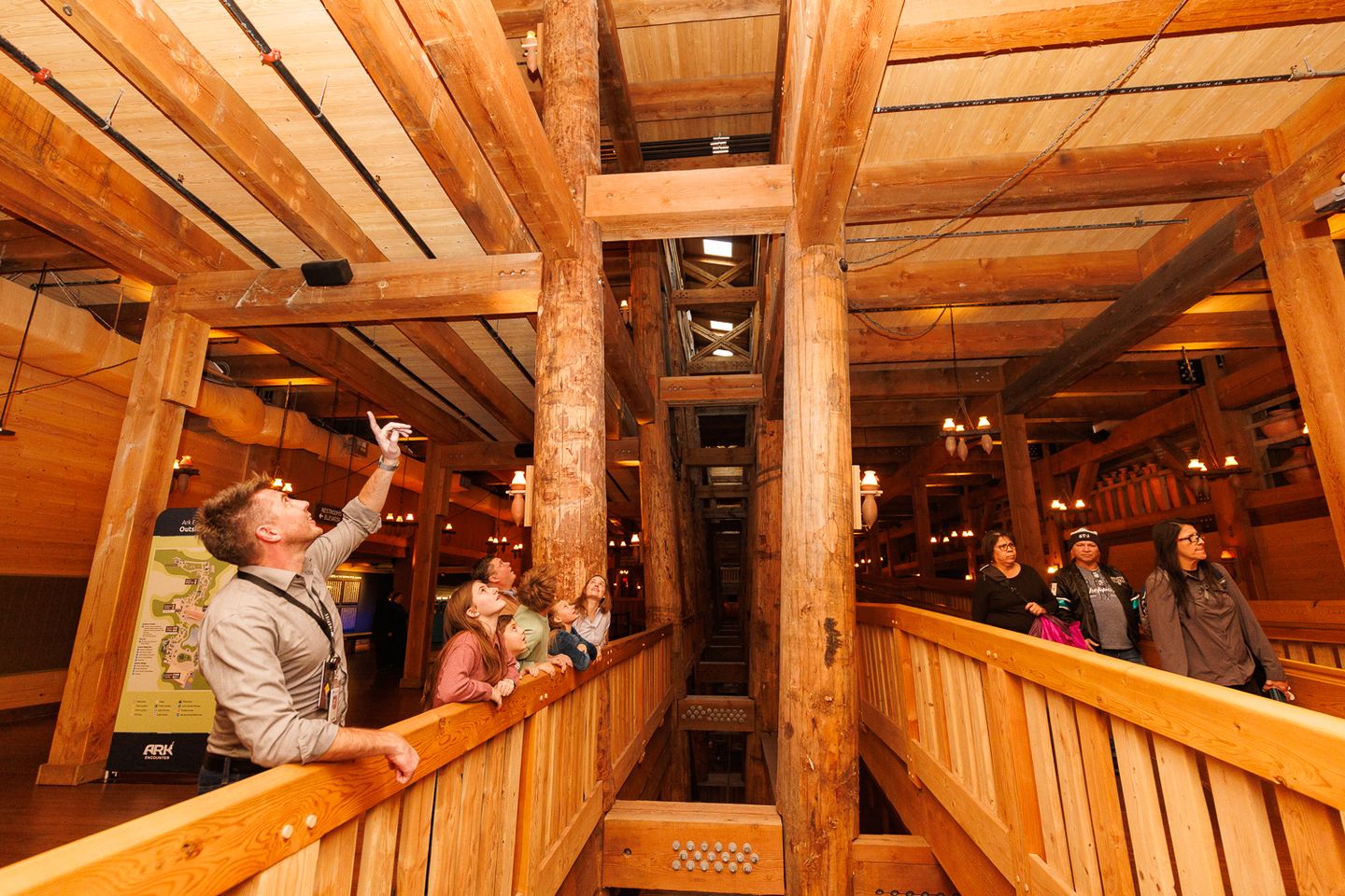 An Inspire guide explains the massive timber framework of Noah's Ark as guests look up during a guided tour inside the Ark Encounter.