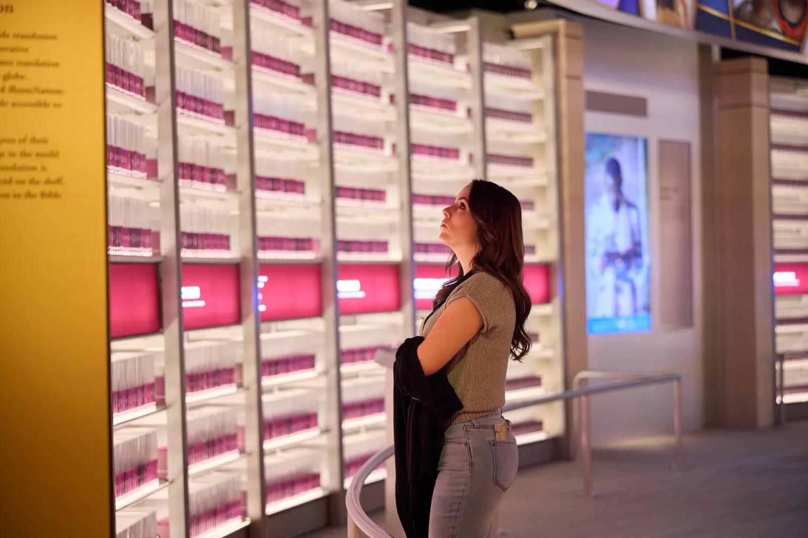 A guest at Museum of the Bible looks on at IllumiNations, the room representing Bibles translated into different languages.