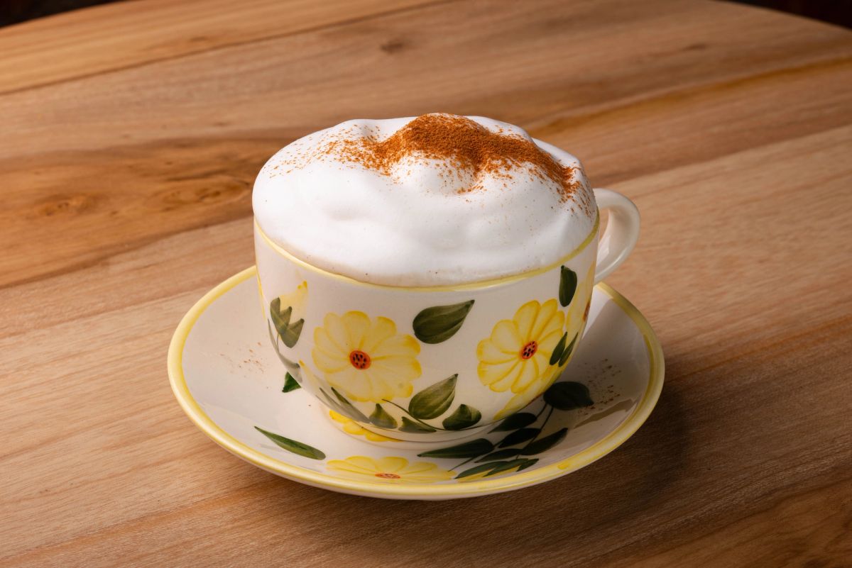 Manos expertas de barista creando arte latte con precisión y cuidado