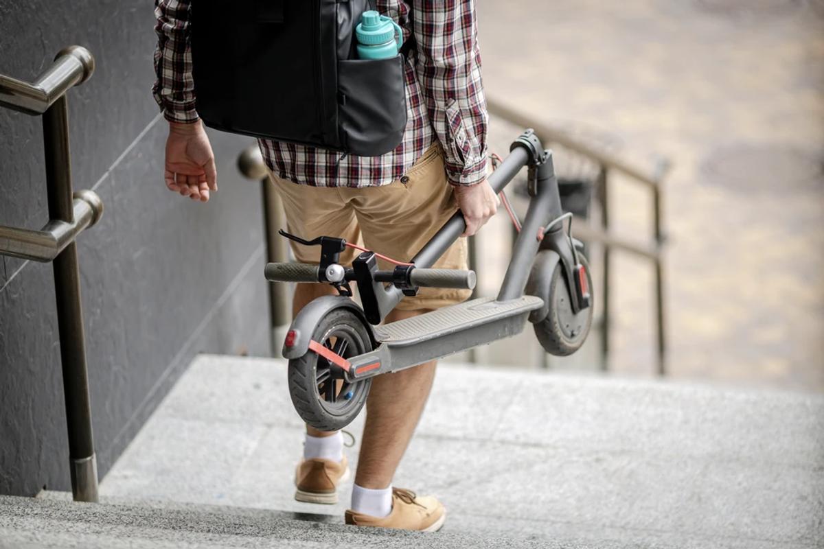  jeune homme se rend à son travail avec une trottinette pliable 