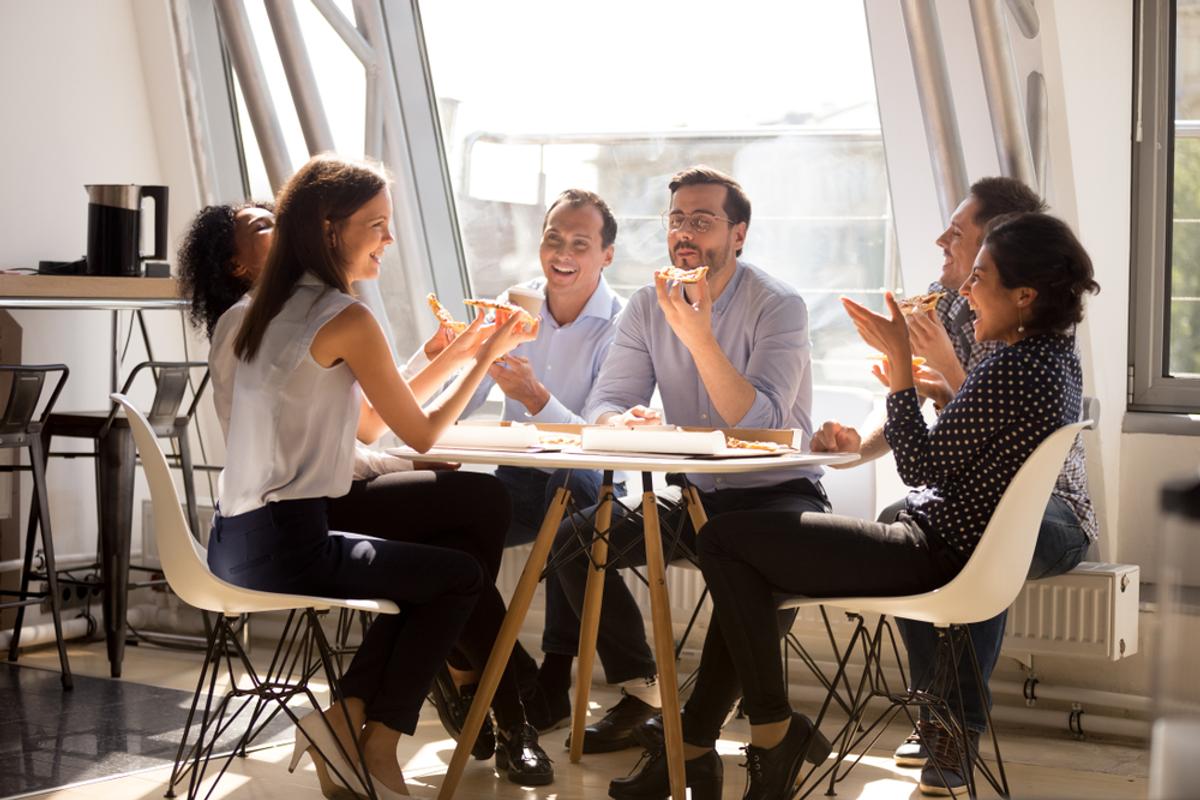 Des salariés heureux en train de manger en équipe au bureau
