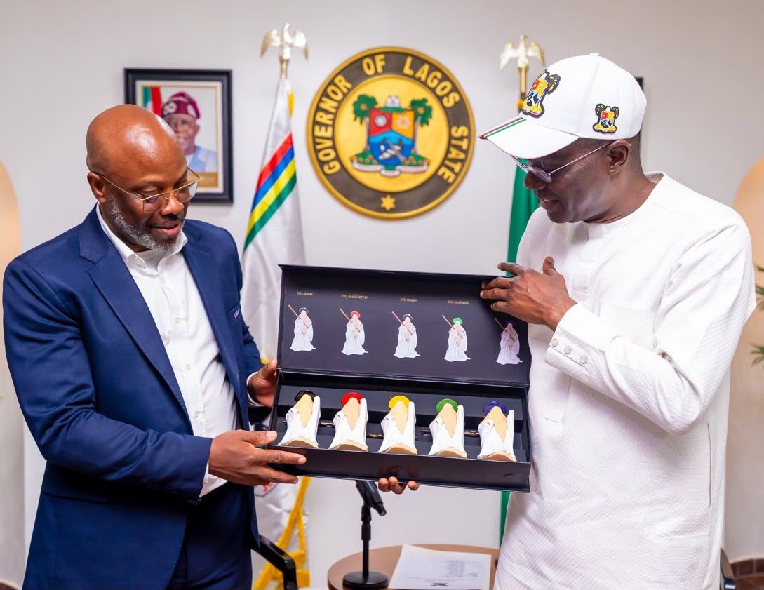 Lagos State Governor Babajide Sanwo-Olu and CAF delegation head Christian Emeruwa hold a trophy presentation box.