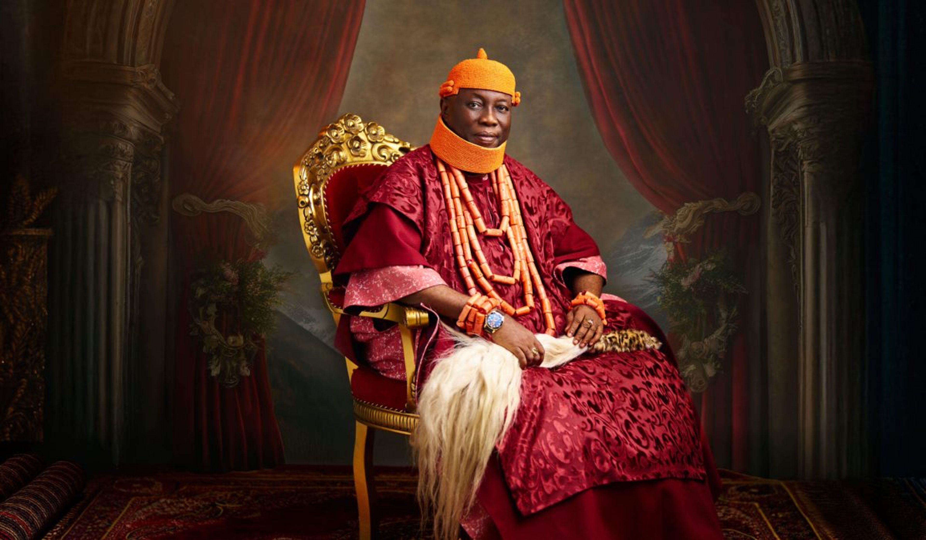official portrait of the Asagba of Asaba, HRM Prof. Epiphany Azinge, seated on a golden throne in royal red and coral regalia
