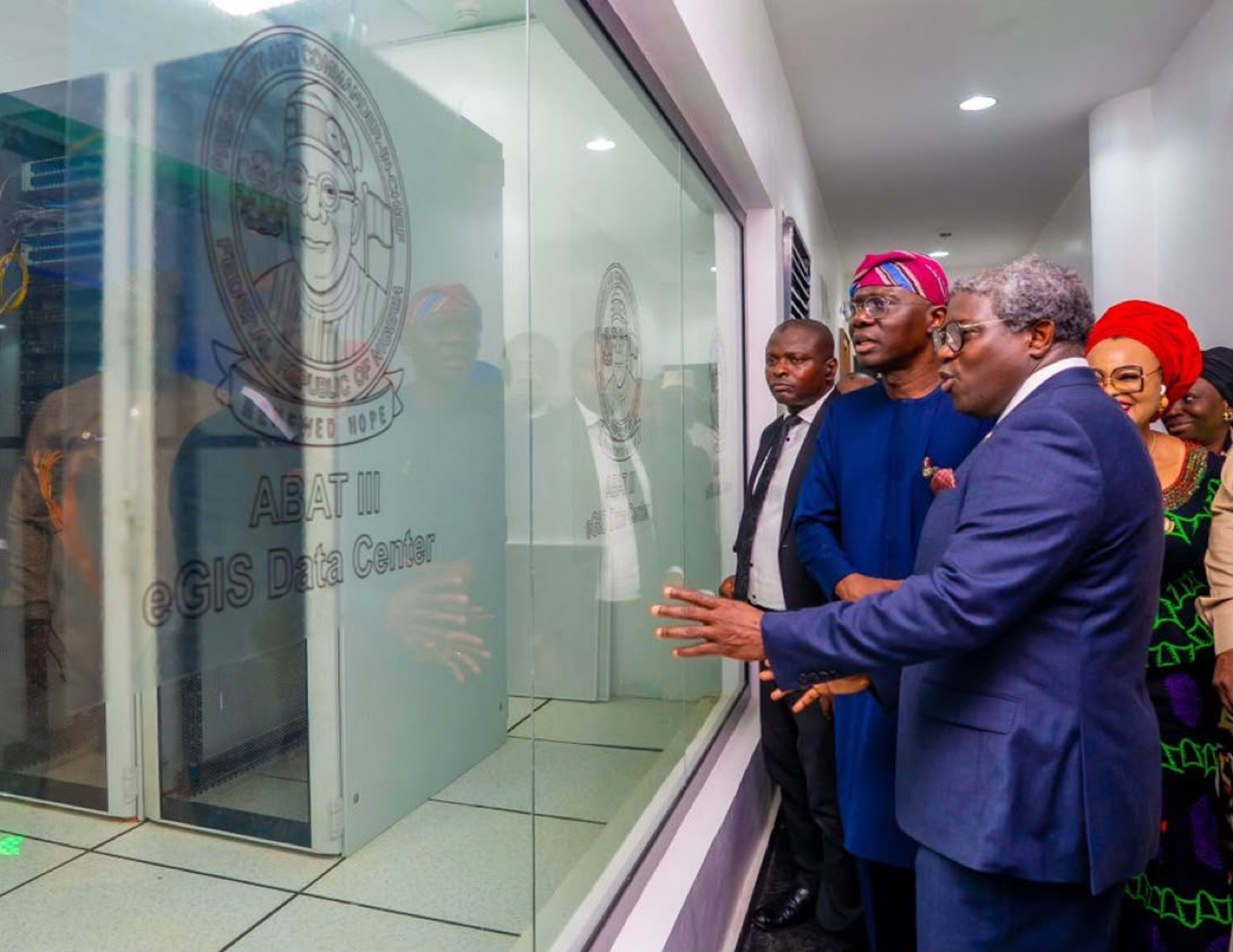 Governor Babajide Sanwo-Olu and officials inspect a digitized facility, looking though a glass panel labeled “Egis Data Center”. 