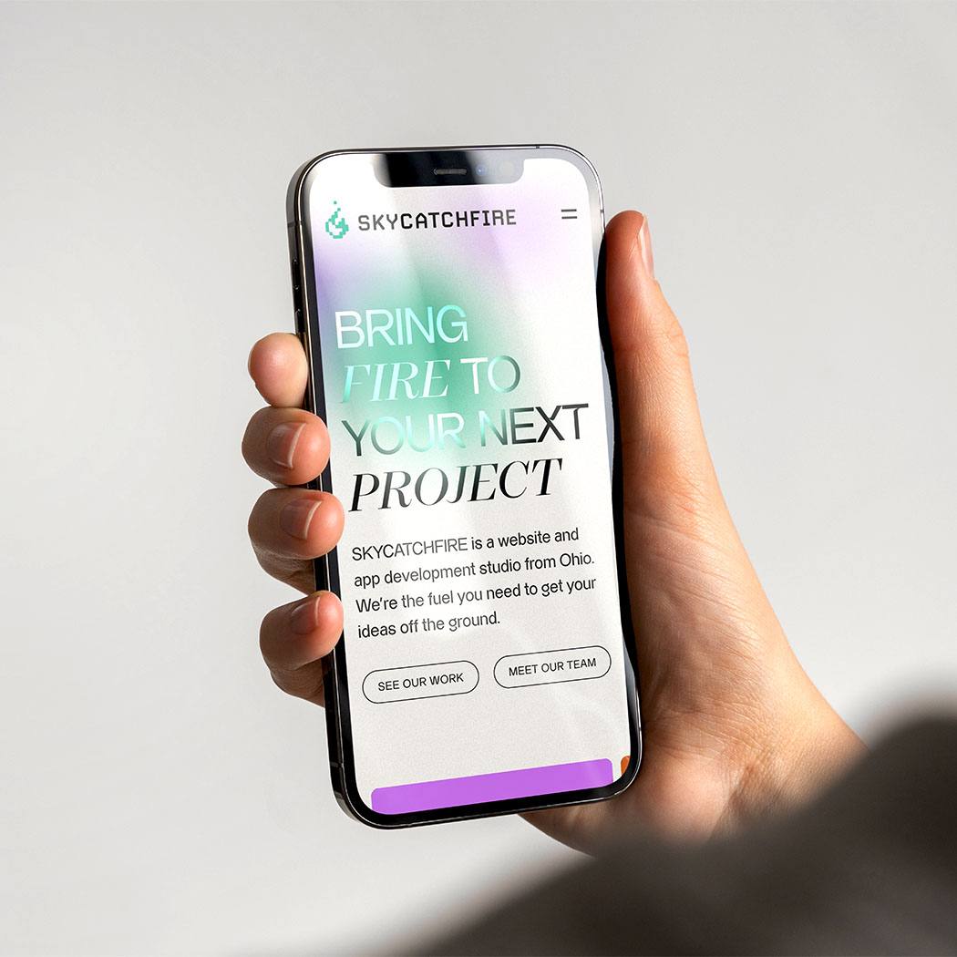 Image of the SKYCATCHFIRE website being displayed on a phone in someone's hand