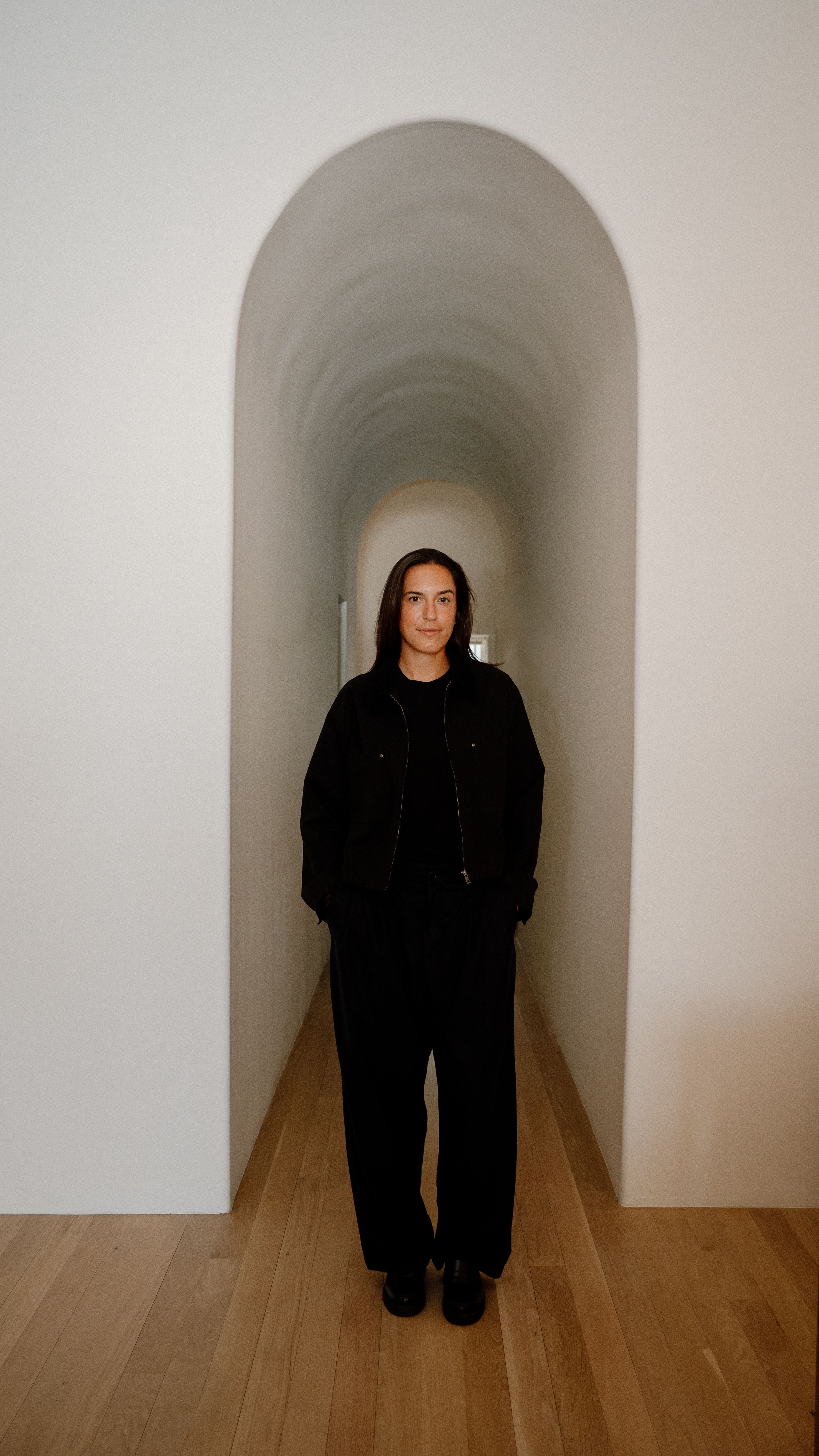 woman stands with hands in pockets