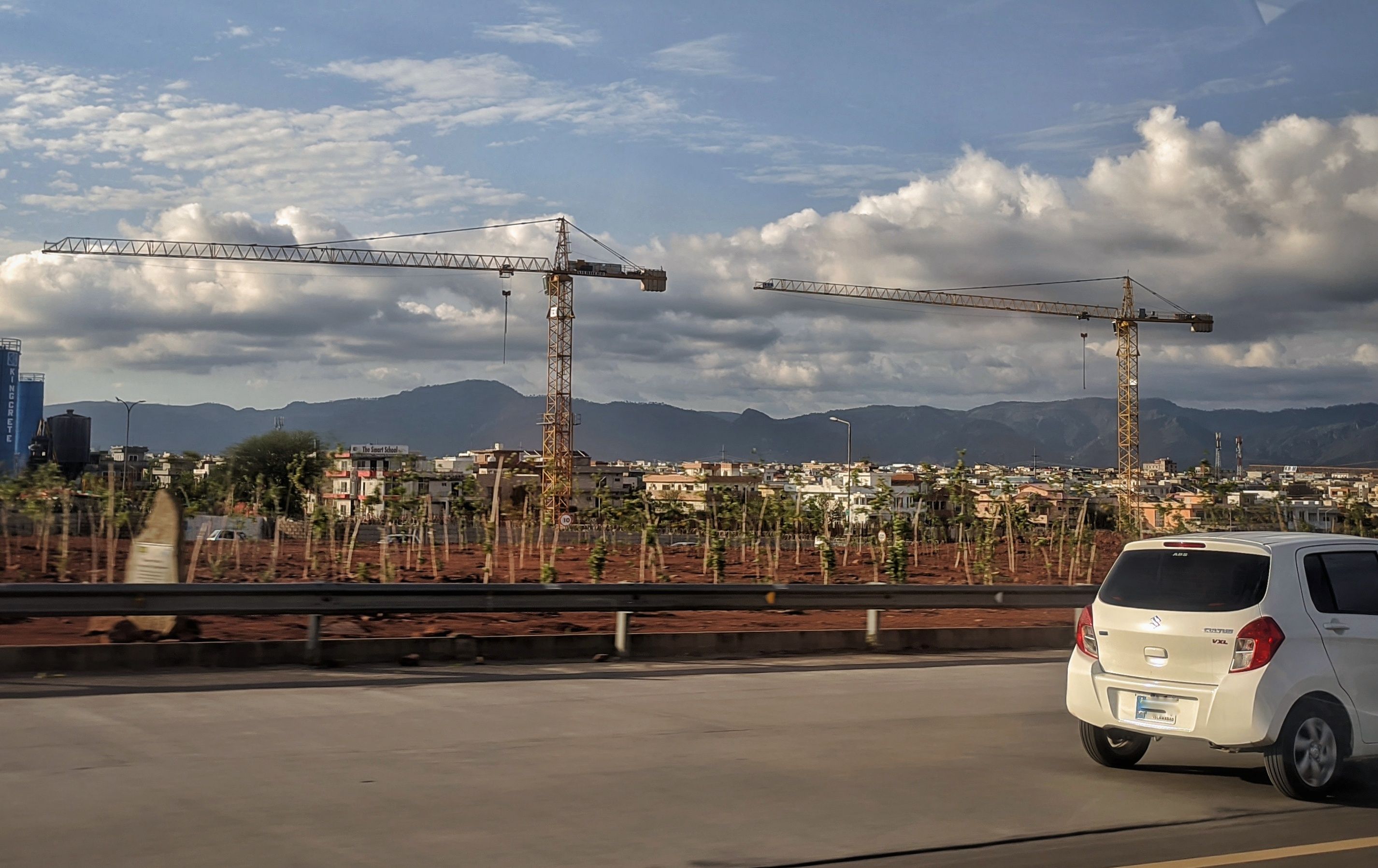 Construction cranes over sector G-13, Islamabad, with the Margalla Hills behind