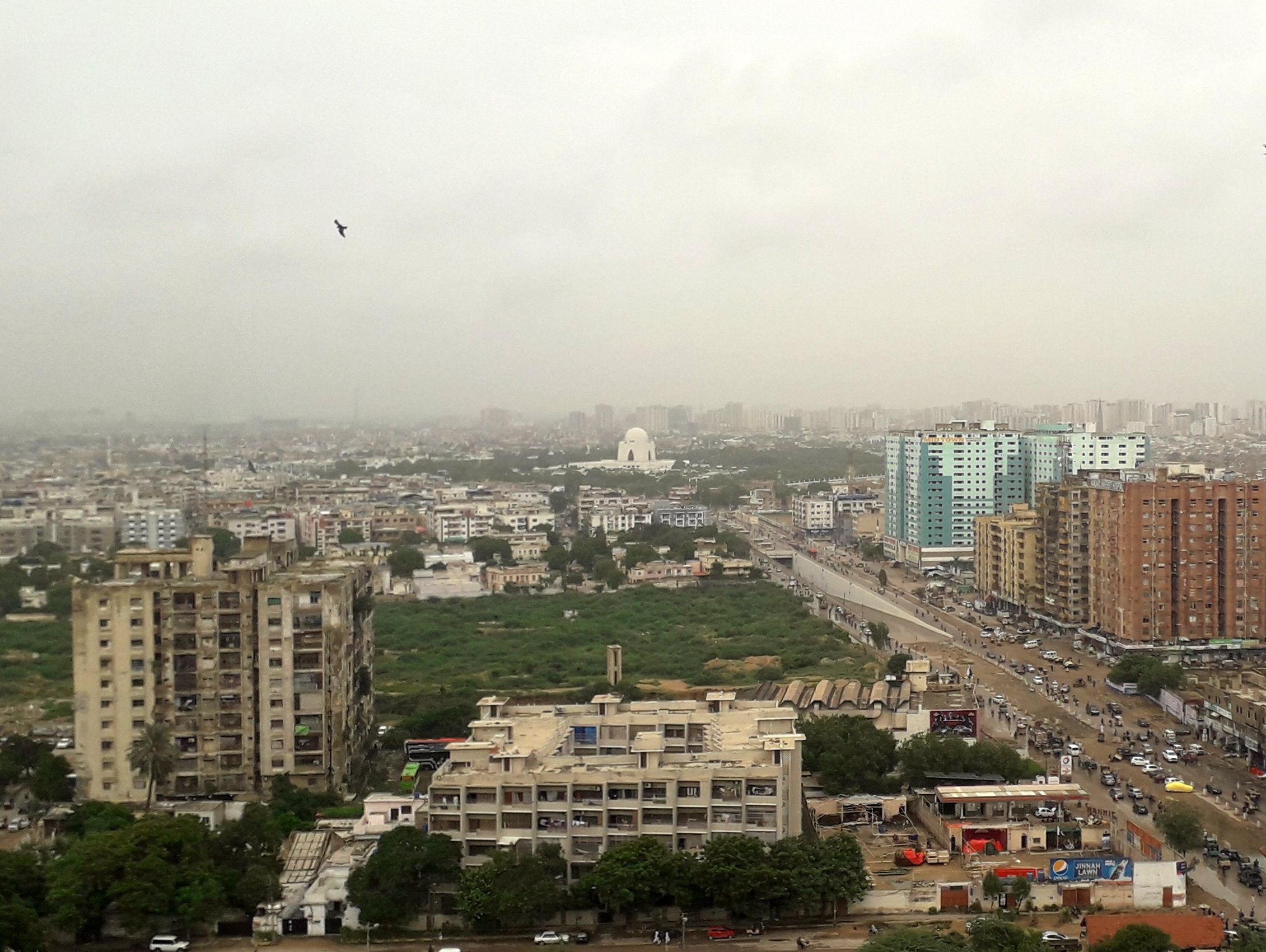 Apartment buildings across Karachi, with Mazar-e-Quaid in the distance