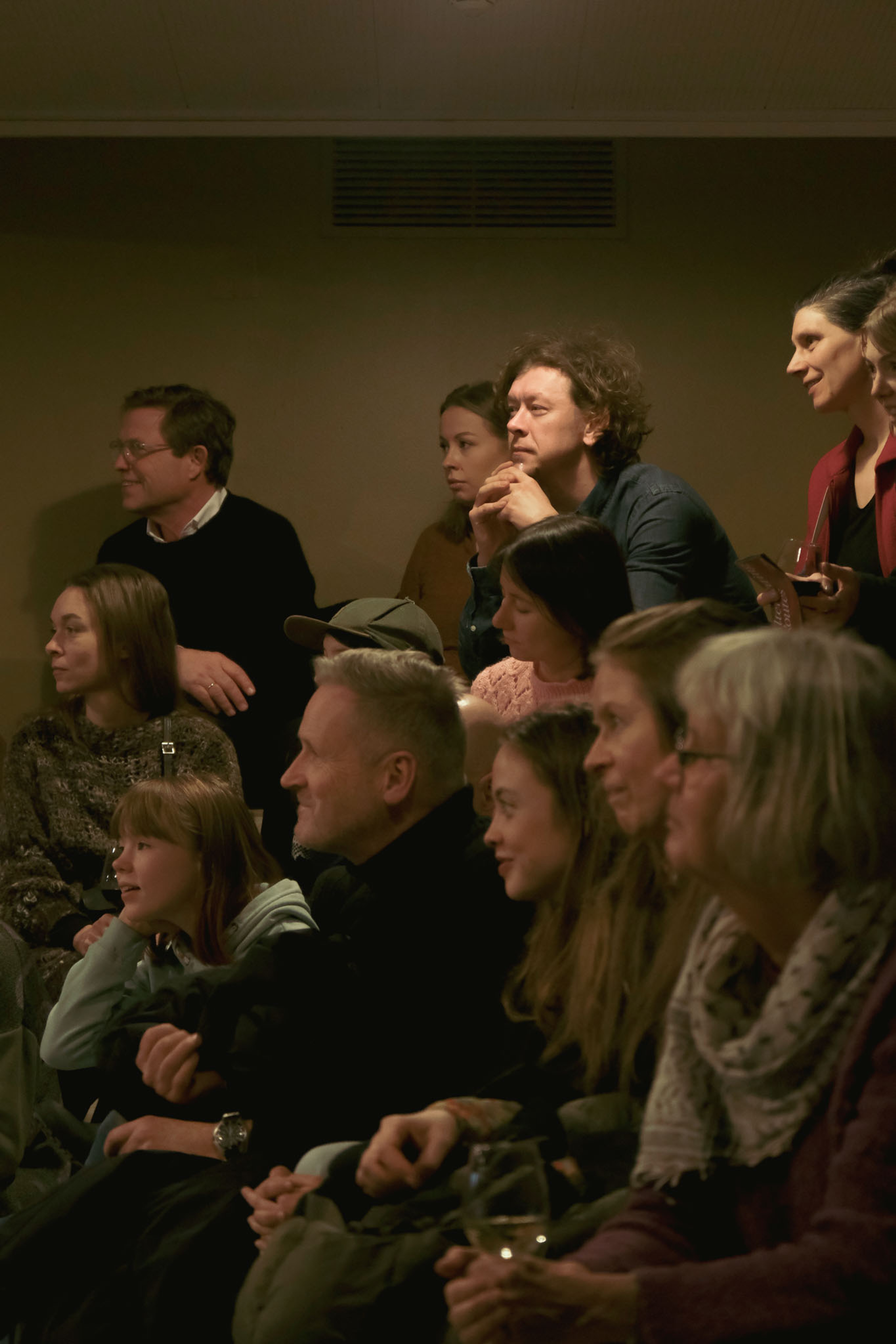 Lots of people sitting on different levels and looking to the left.