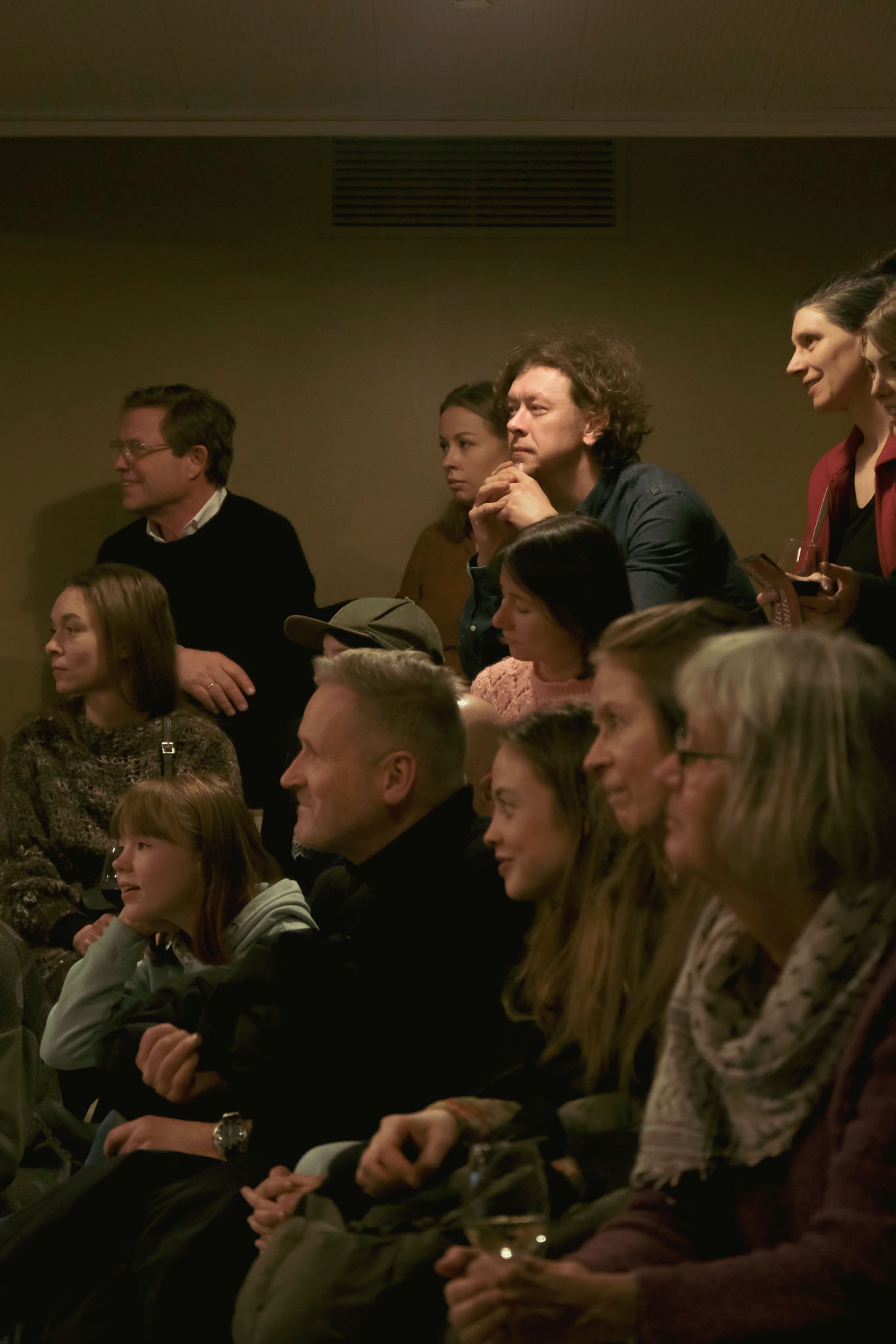 Lots of people sitting on different levels and looking to the left.