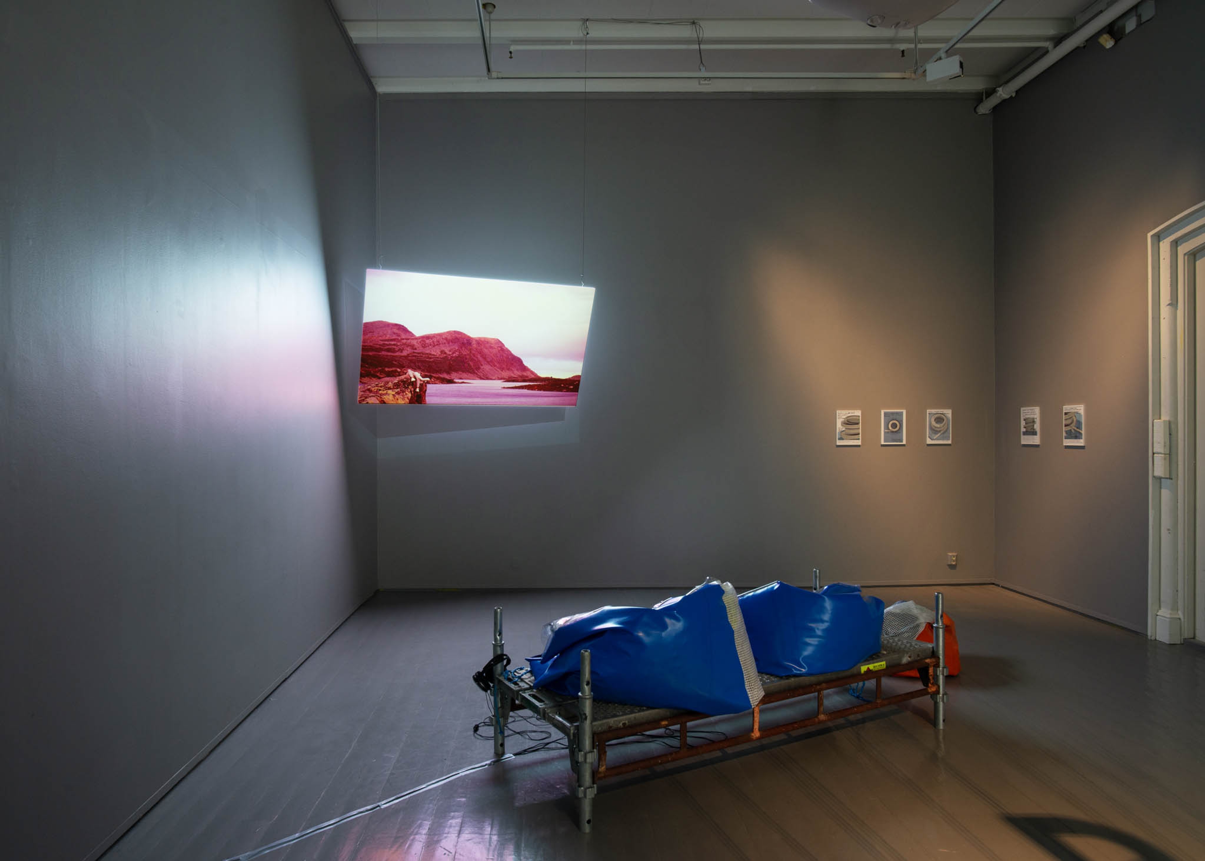 A bench built from scaffold sits in front of a screen.