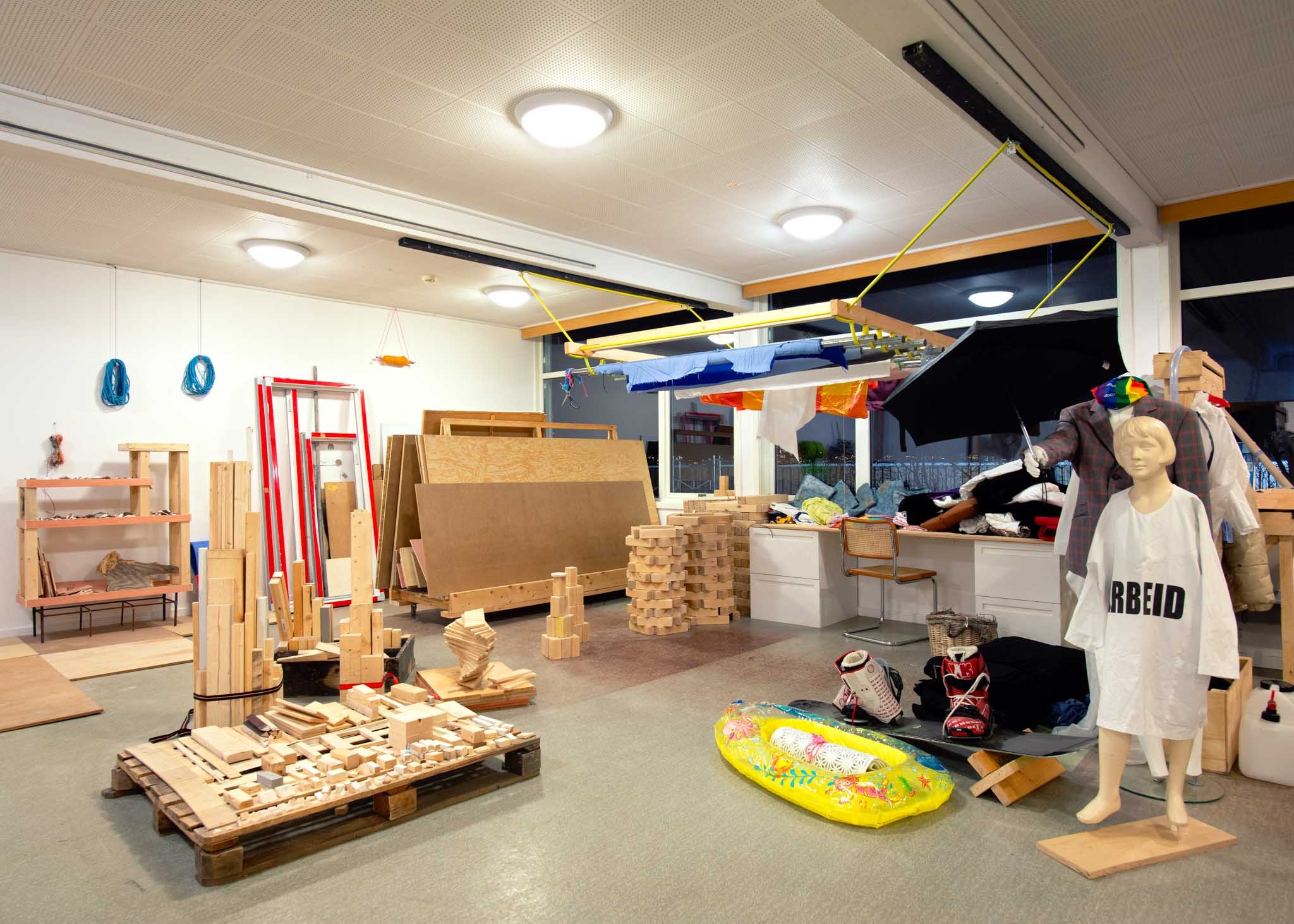 Various wooden objects are arranged by form and size. A mannequin stands on the right.