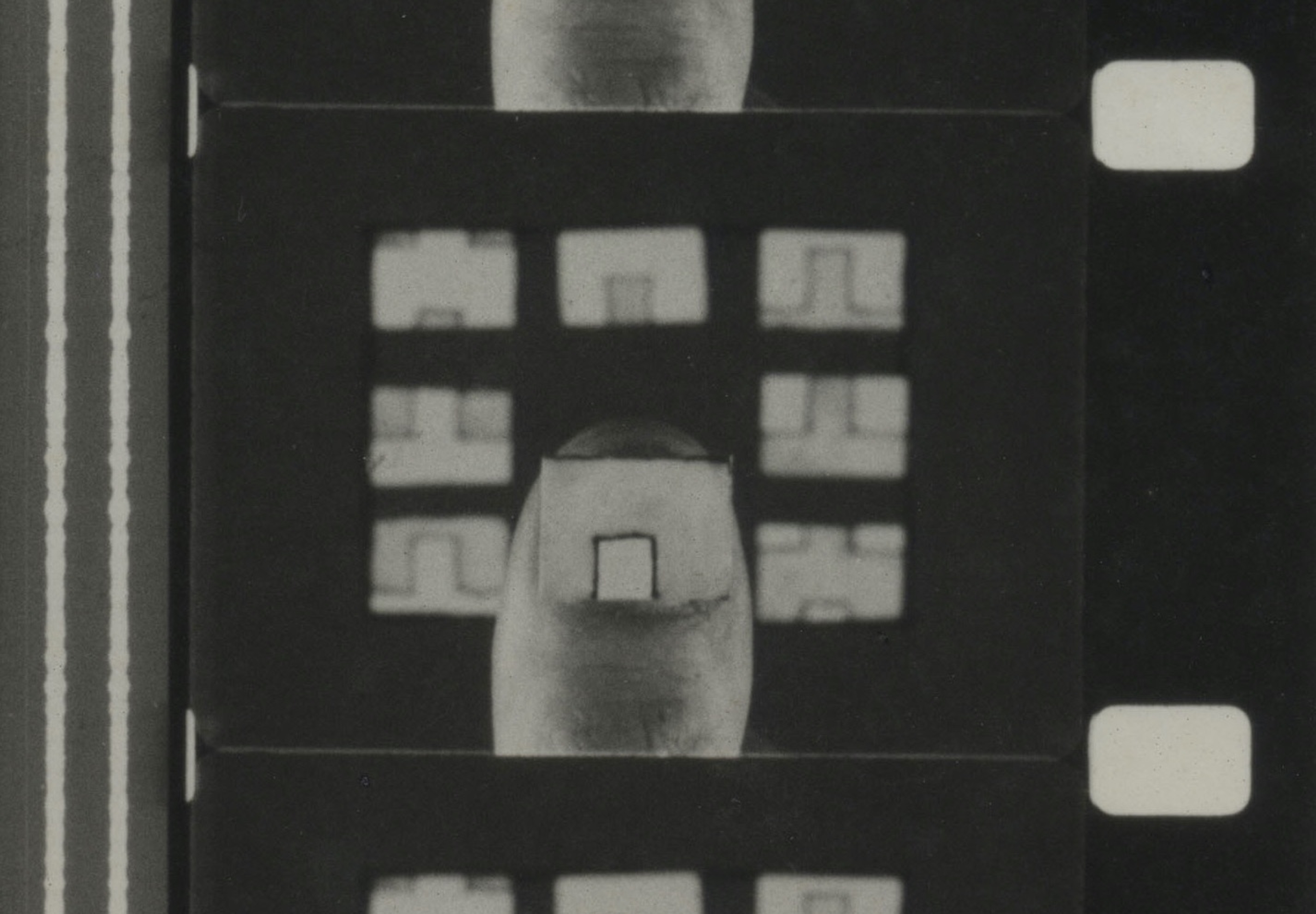 En filmstrimmel viser en tommel med et stykke papir på.