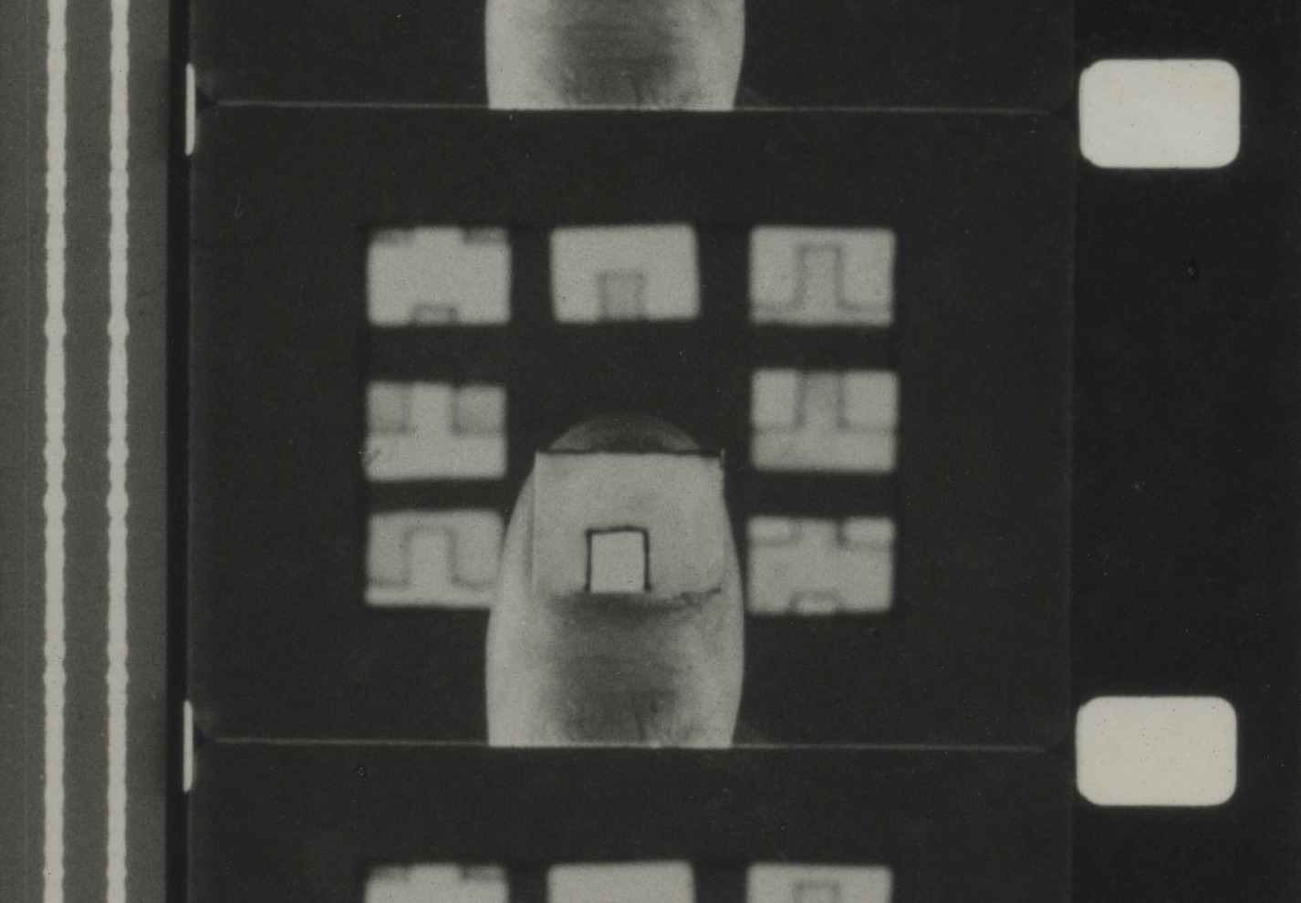 En filmstrimmel viser en tommel med et stykke papir på.