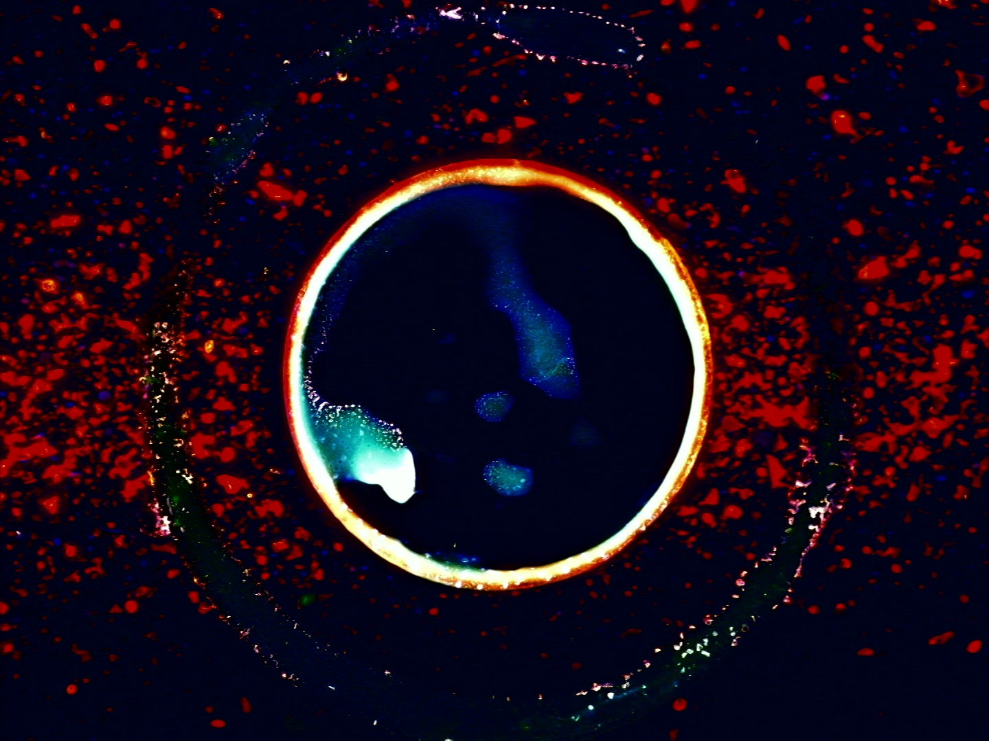 Hvitt omgir dypblått i midten av røde malingssprut.