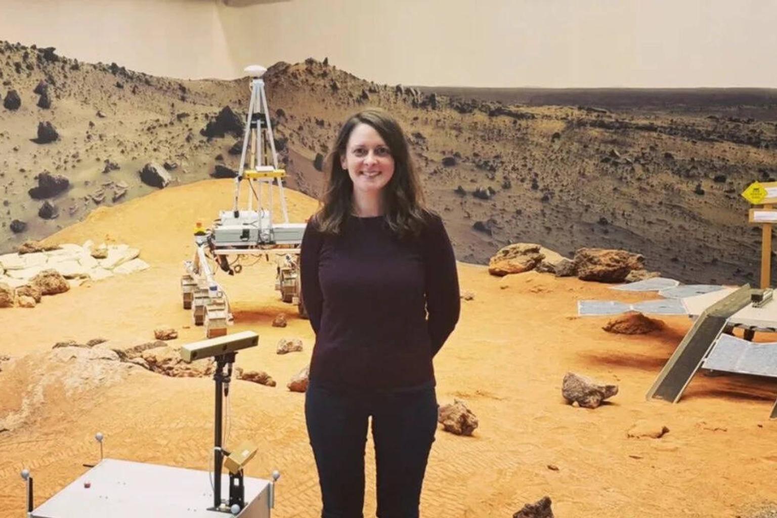Claire Parfitt in a space suit with a Mars landscape background