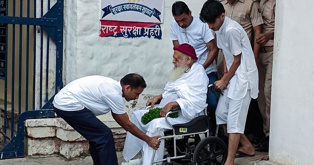 Asaram being led away by police in a crowded courtroom scene