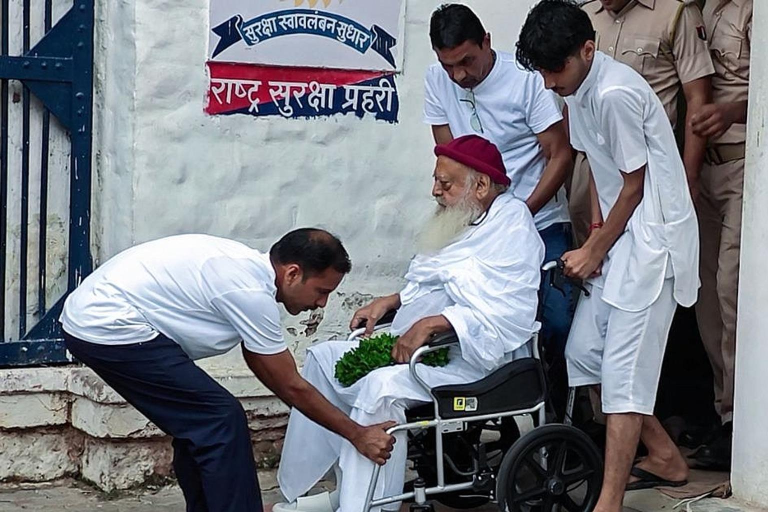 Asaram being led away by police in a crowded courtroom scene