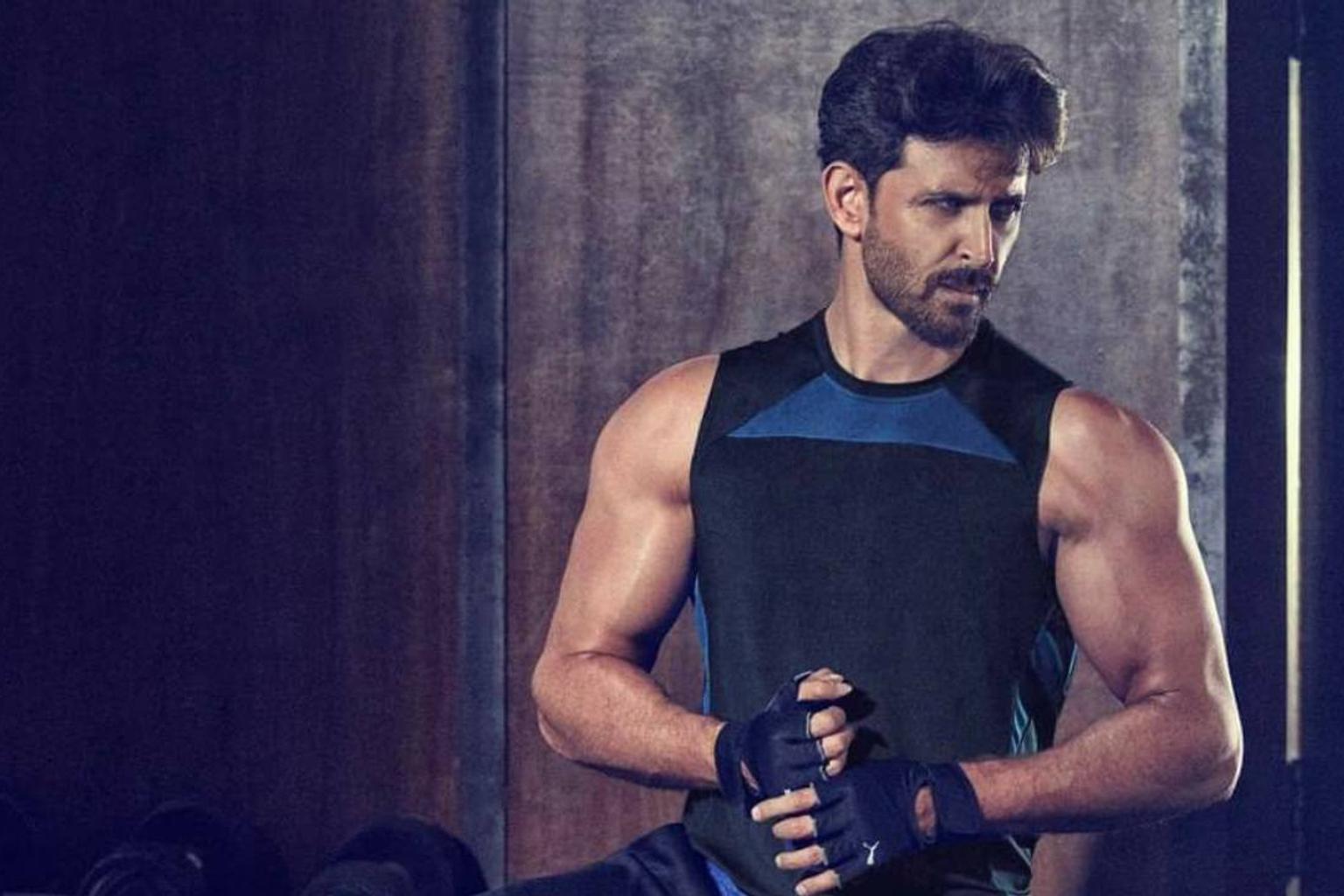 Hrithik Roshan posing with Cult.fit logo and fitness equipment