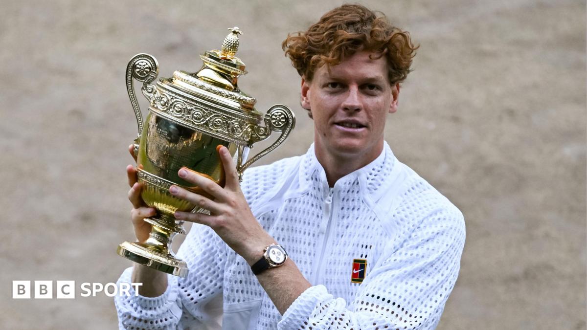 Jannik Sinner holding Wimbledon trophy on court