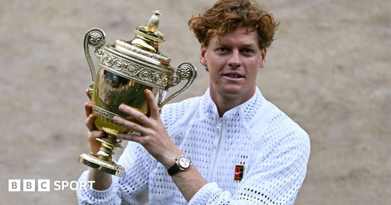 Jannik Sinner holding Wimbledon trophy on court