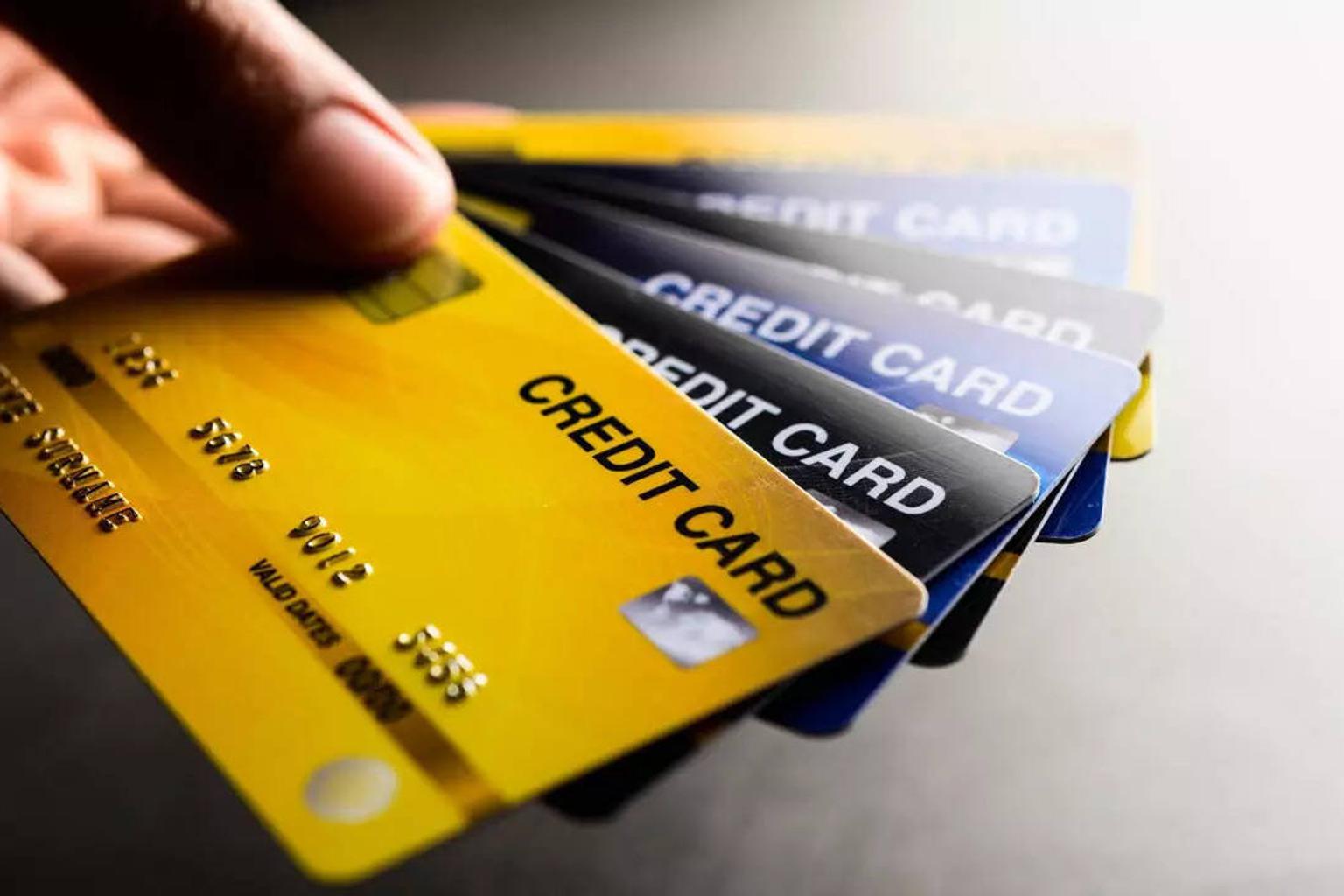 Person holding a credit card and using a laptop