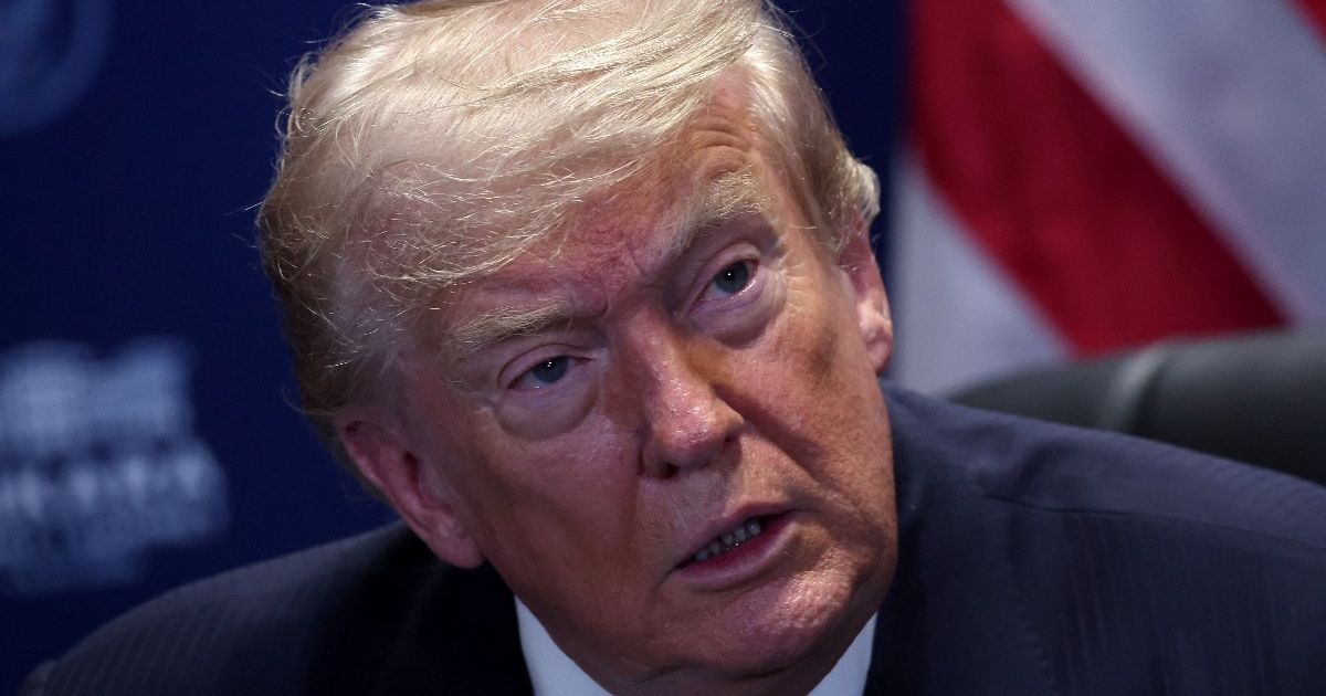 US President Donald Trump speaking at a podium with a serious expression