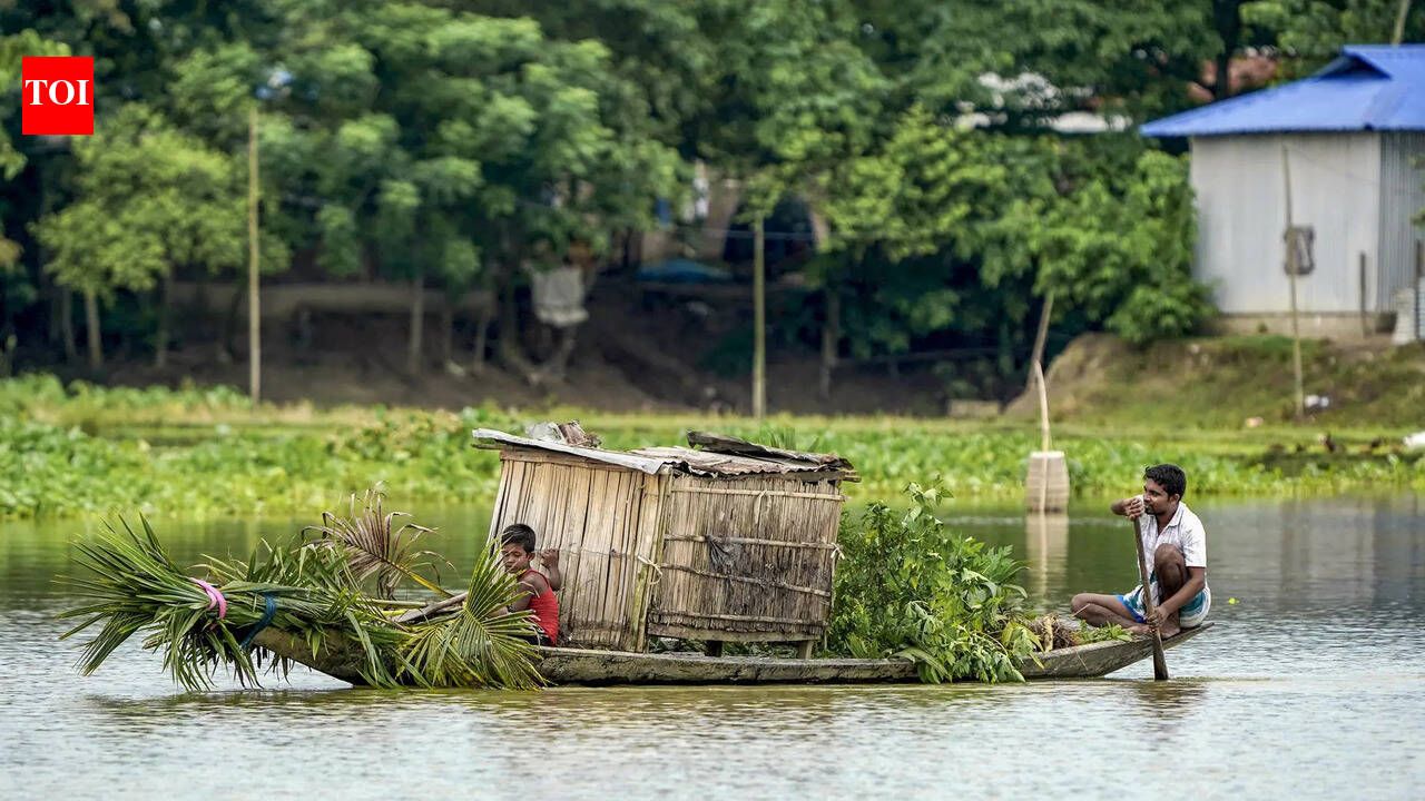People crossing a flood-affected area on a boat in Morigaon district
