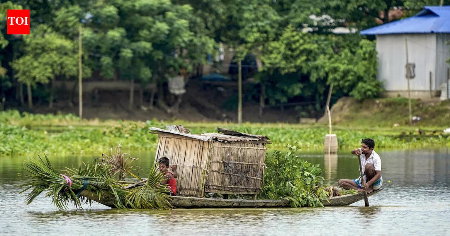 People crossing a flood-affected area on a boat in Morigaon district