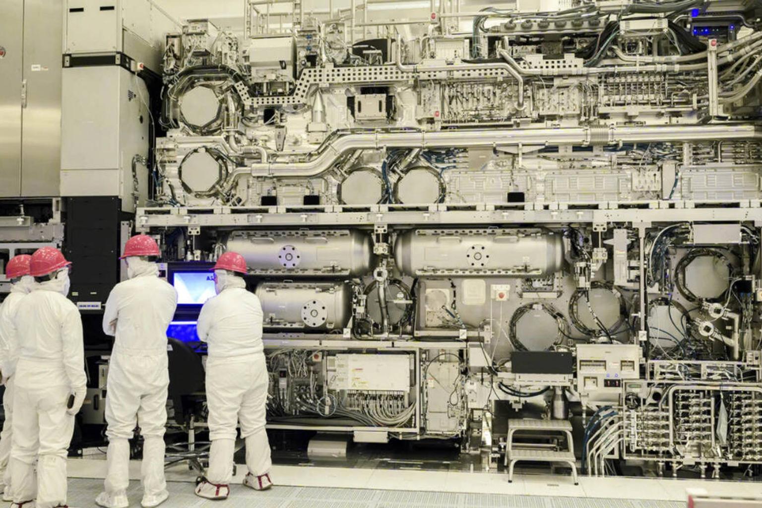 Scientists working on a complex machine in a laboratory
