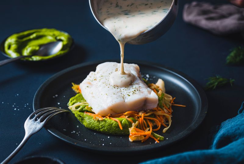 Fiskesaus som helles over fisken