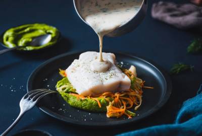 Fiskesaus som helles over fisken