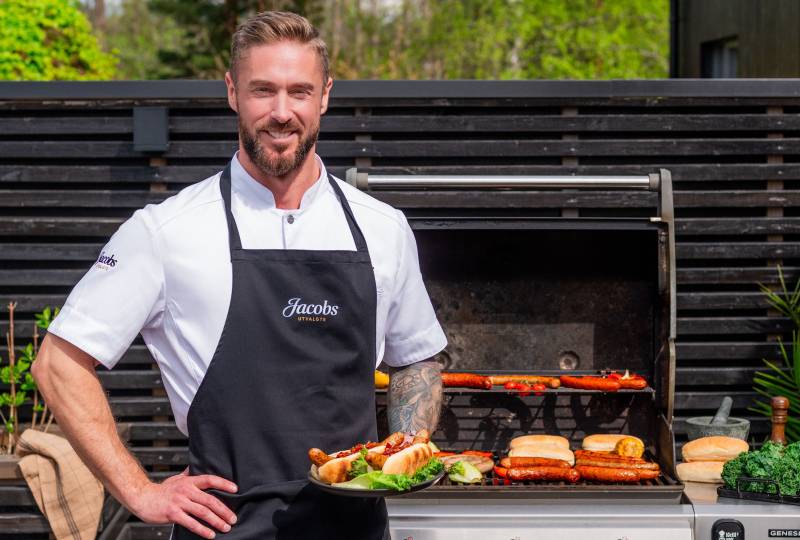 Kokken med pølser fra grillen