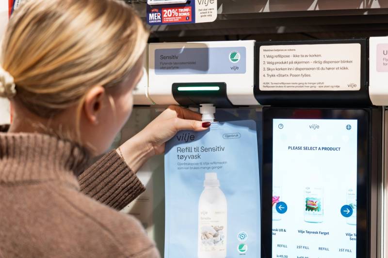 Kvinne fyller en refillpose med senstiv vaskemiddel