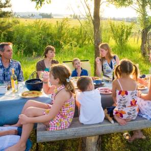 Storfamilie er samlet rundt et måltid i hagen