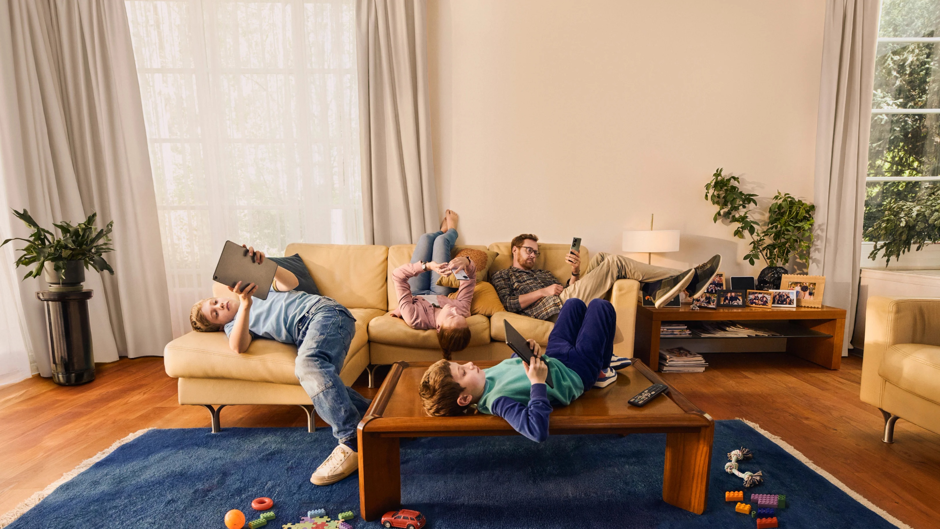 Family sitting on couch on their devices