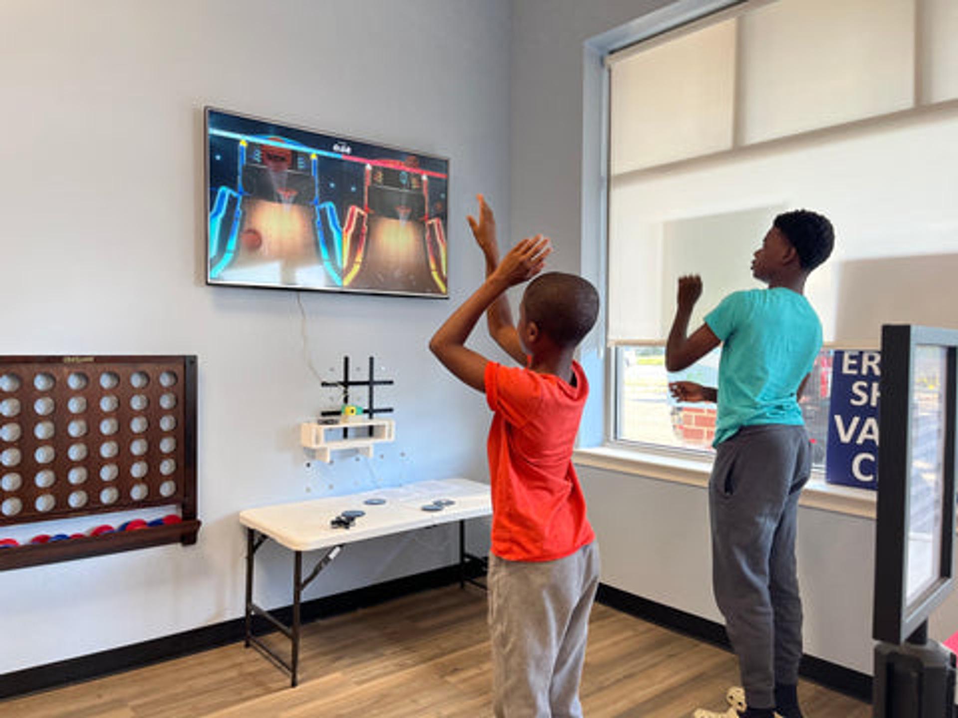 Children using active gaming to stay entertained during a vaccine visit at a local pharmacy with the Nex Playground system.
